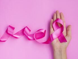 close-up-pink-ribbon-hand-isencao-imposto-renda-cancer-mama-scaled.jpg